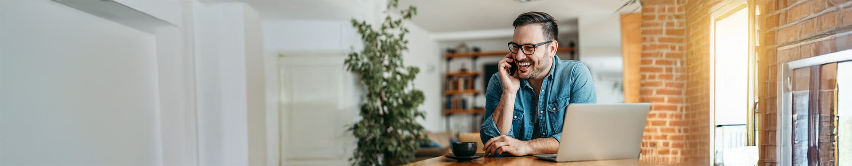 Smiling man at home talking on the phone