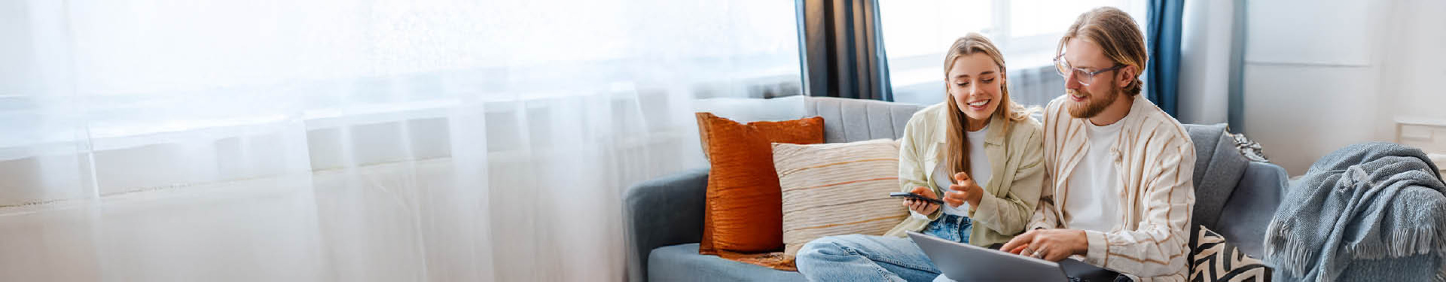 Couple on sofa looking at laptop
