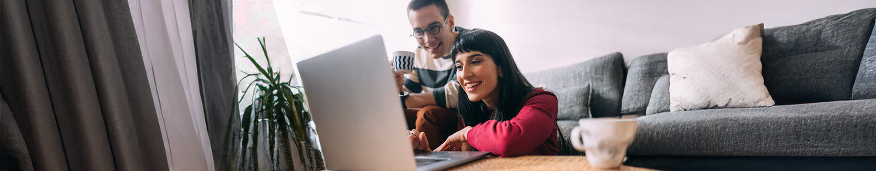 Couple in sitting room using laptop