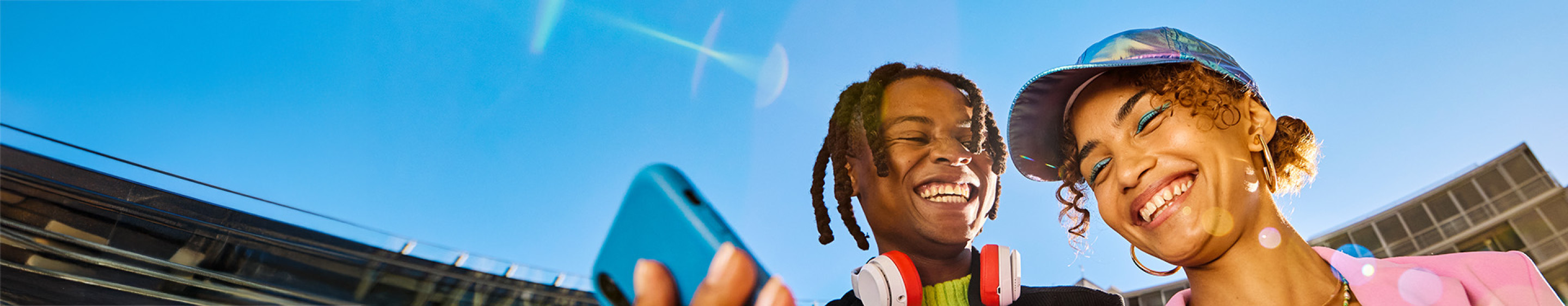 Two young people outside looking at a phone and smiling